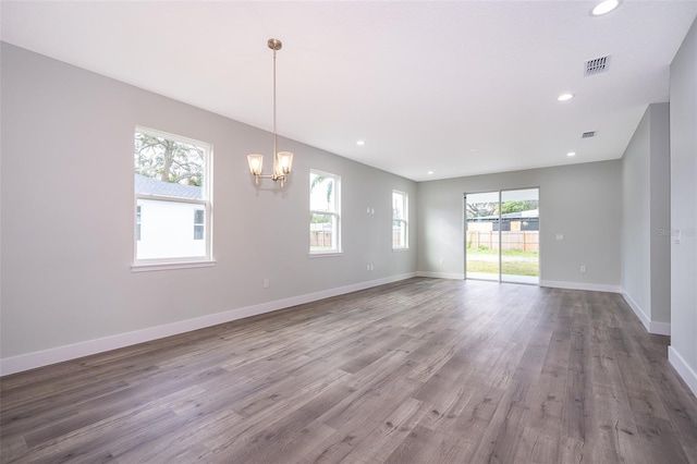 spare room featuring a notable chandelier and hardwood / wood-style floors