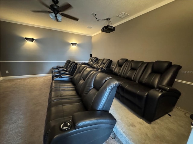 carpeted cinema with ceiling fan, ornamental molding, visible vents, and baseboards