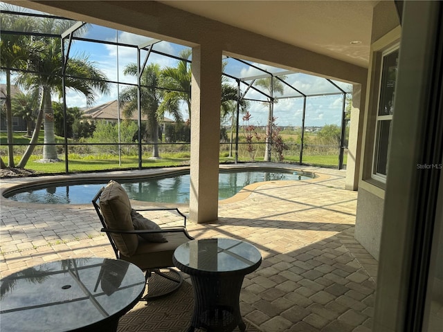 outdoor pool featuring glass enclosure and a patio area