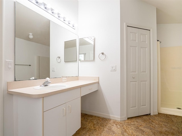 bathroom featuring walk in shower and vanity