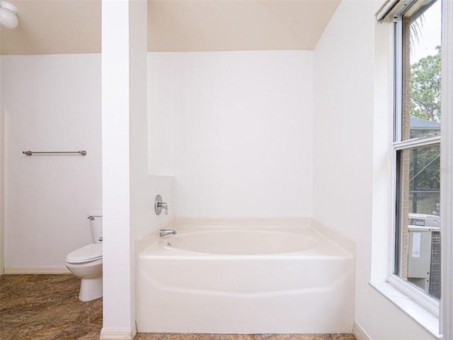 bathroom with toilet and a tub to relax in