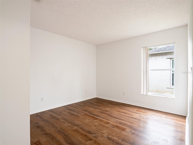 unfurnished room with a textured ceiling and hardwood / wood-style floors