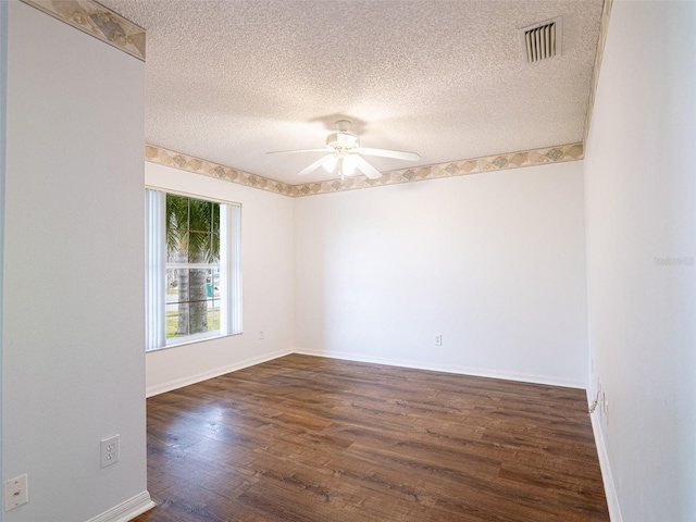 spare room with ceiling fan, dark wood-type flooring, and a textured ceiling