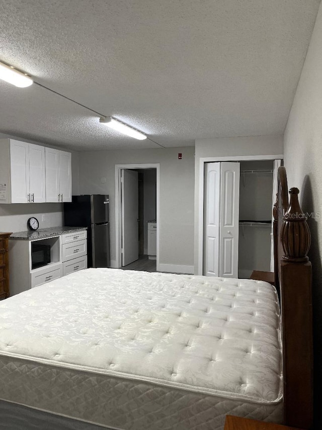 unfurnished bedroom featuring stainless steel refrigerator and a textured ceiling