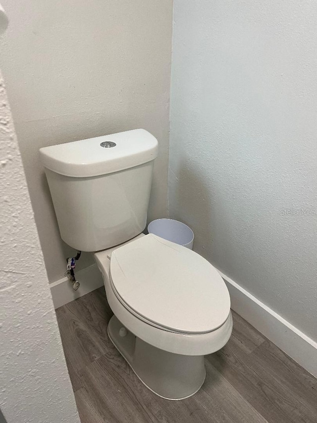 bathroom featuring wood-type flooring and toilet