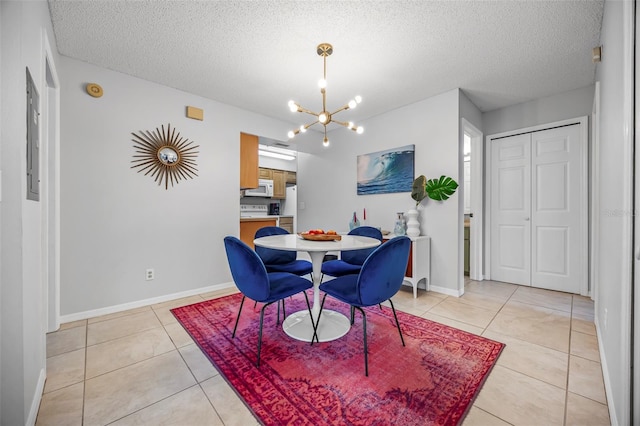 tiled dining space with a textured ceiling and a chandelier