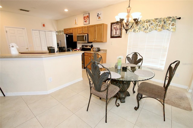 tiled dining space featuring a notable chandelier