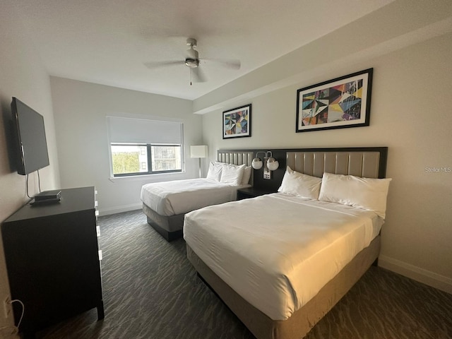 bedroom featuring ceiling fan and dark carpet