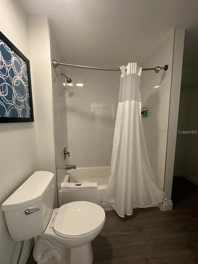 bathroom with hardwood / wood-style flooring, shower / tub combo with curtain, a textured ceiling, and toilet