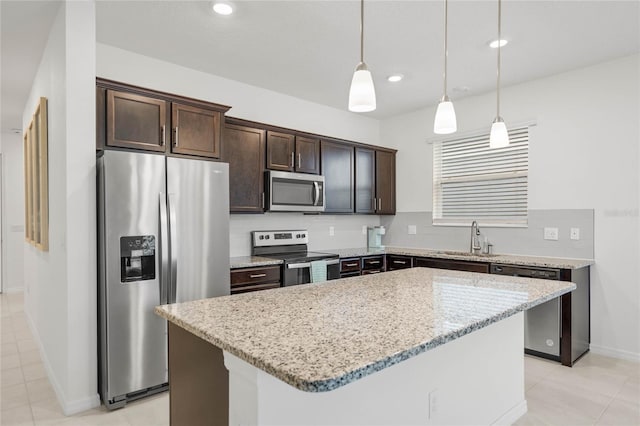 kitchen featuring dark brown cabinets, stainless steel appliances, sink, pendant lighting, and a center island