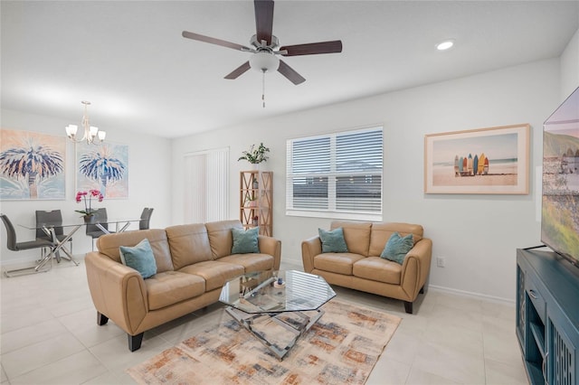 tiled living room with ceiling fan with notable chandelier