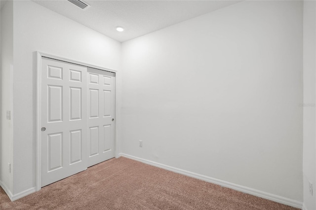 unfurnished bedroom featuring carpet flooring and a closet