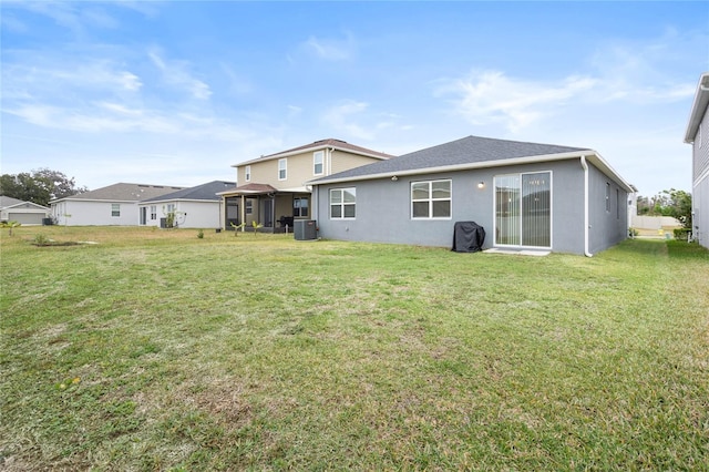 rear view of house featuring a yard and central AC