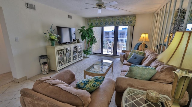 tiled living room featuring a textured ceiling and ceiling fan