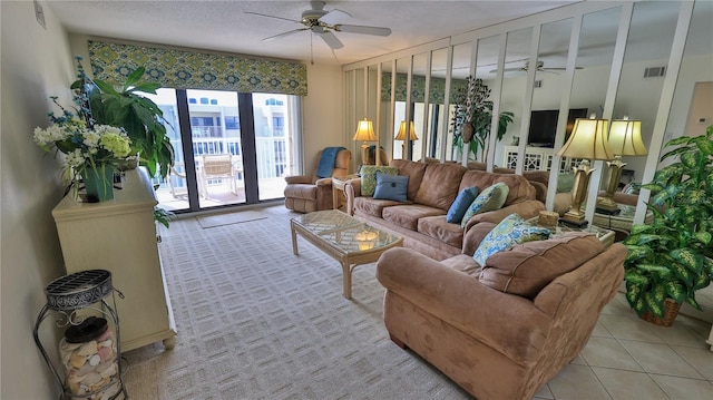 tiled living room with a textured ceiling and ceiling fan