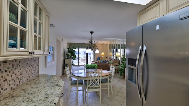 dining space with light tile patterned floors and a chandelier