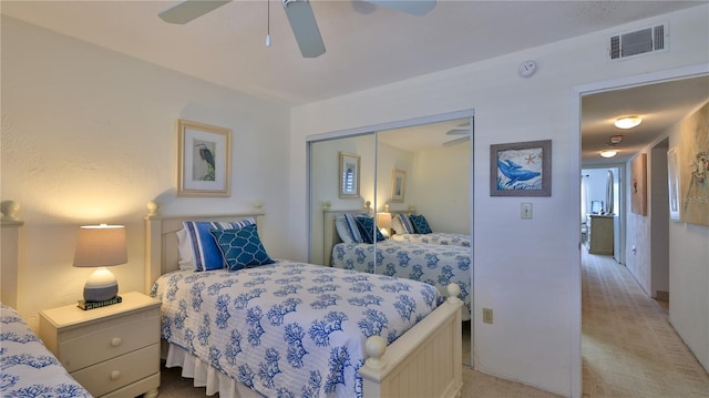 carpeted bedroom featuring ceiling fan and a closet