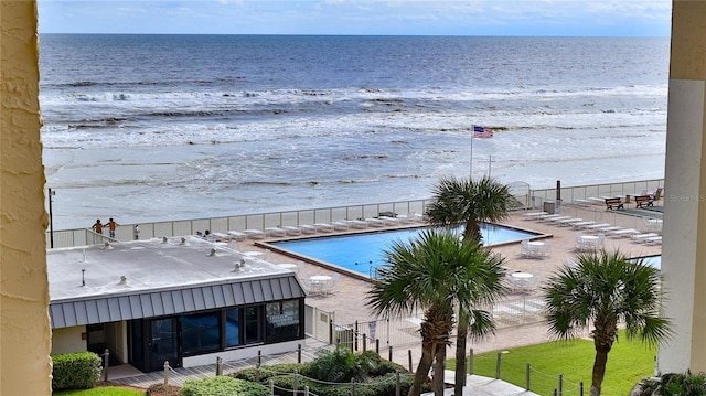 view of pool featuring a patio area, a beach view, and a water view