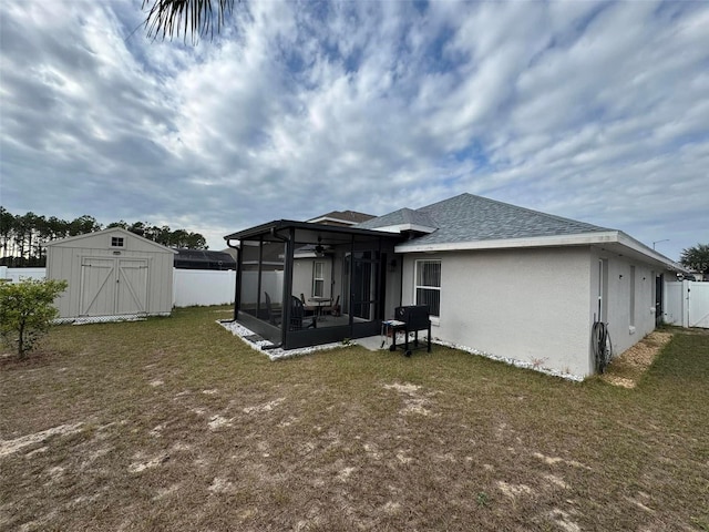 back of property featuring a storage unit, a yard, and a sunroom