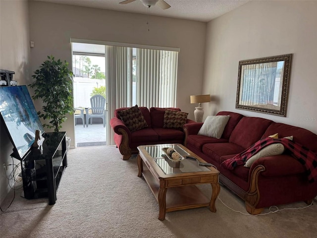 living room with a textured ceiling, ceiling fan, and carpet flooring