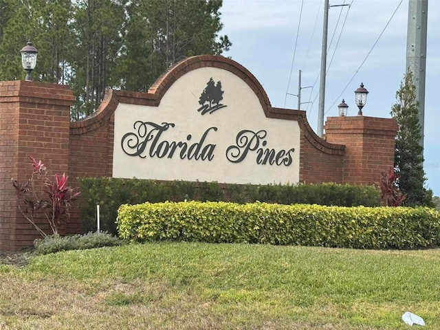 community / neighborhood sign featuring a lawn