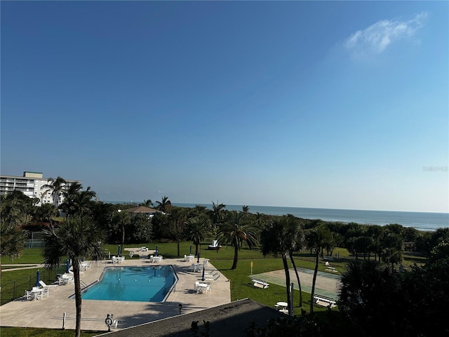 view of swimming pool with a water view, a patio area, and a lawn