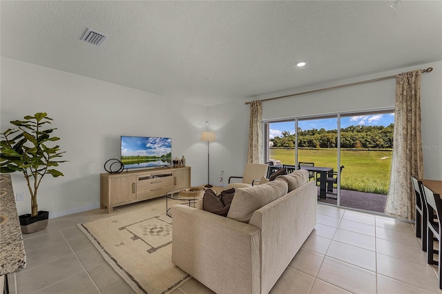 living room featuring light tile patterned flooring and a textured ceiling