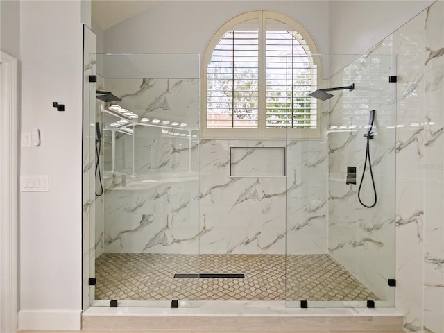 bathroom featuring a shower with door and lofted ceiling