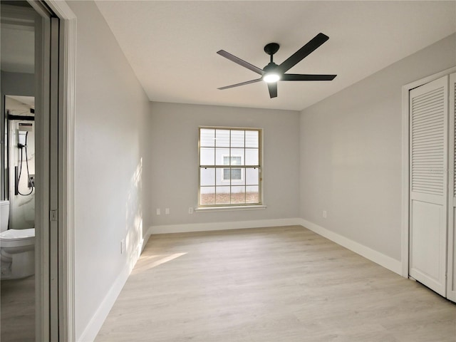 unfurnished bedroom featuring ceiling fan, light wood-type flooring, connected bathroom, and a closet