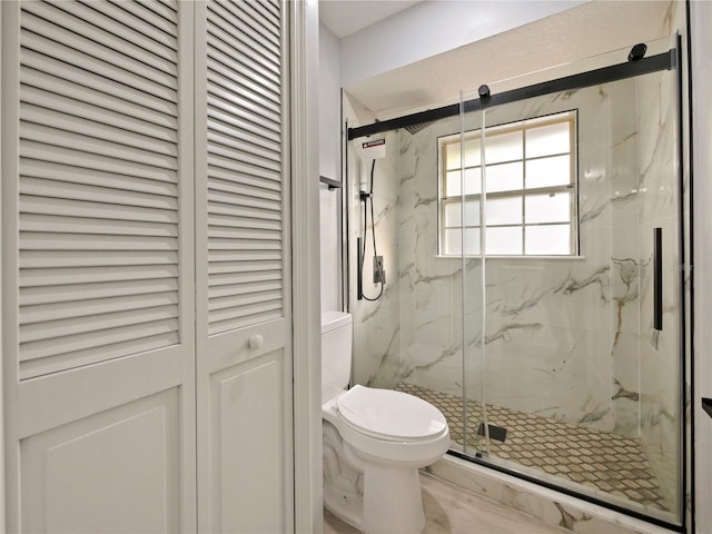 bathroom with an enclosed shower and toilet