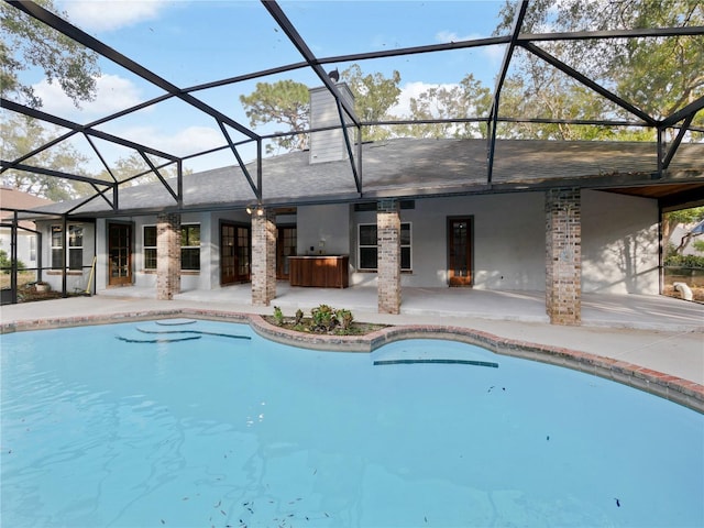 view of swimming pool with glass enclosure and a patio area