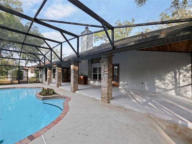 view of swimming pool featuring a patio and a lanai