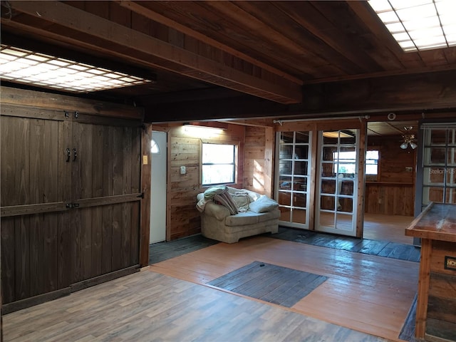 entrance foyer featuring hardwood / wood-style flooring, beam ceiling, and wood walls