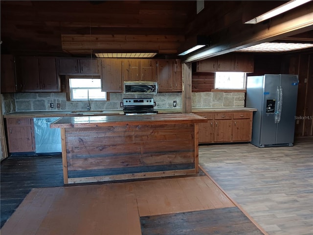 kitchen with sink, decorative backsplash, stainless steel appliances, and hardwood / wood-style floors