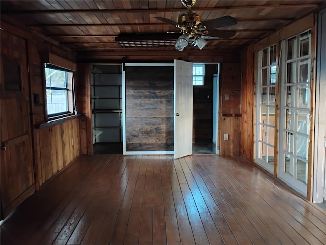 interior space featuring hardwood / wood-style flooring, wooden ceiling, ceiling fan, and wood walls