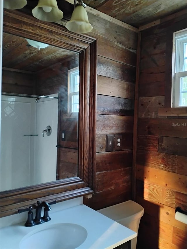 bathroom featuring vanity, wood ceiling, and wooden walls