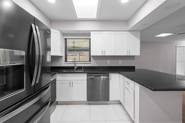 kitchen with kitchen peninsula, white cabinets, black fridge, and stainless steel dishwasher