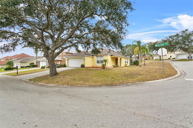 view of front of house featuring a residential view, a front yard, stucco siding, a garage, and driveway