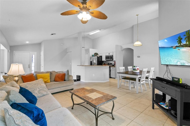 living area featuring light tile patterned floors, a ceiling fan, visible vents, and high vaulted ceiling