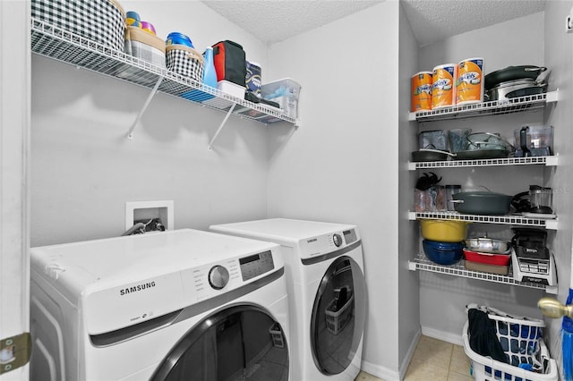 laundry area with baseboards, laundry area, a textured ceiling, washer and dryer, and tile patterned floors