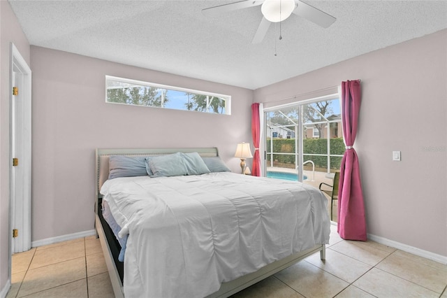 bedroom with light tile patterned floors, baseboards, a textured ceiling, and access to outside