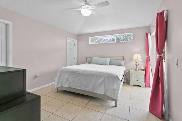 bedroom with a textured ceiling, light tile patterned flooring, baseboards, and ceiling fan