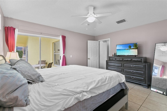 bedroom with access to exterior, visible vents, ceiling fan, light tile patterned floors, and a textured ceiling