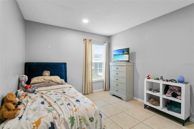 bedroom with light tile patterned floors, baseboards, and a textured ceiling