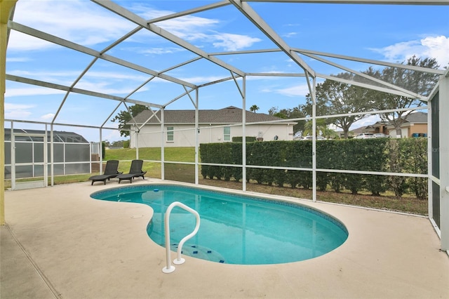 view of pool with glass enclosure, a patio area, and a fenced in pool