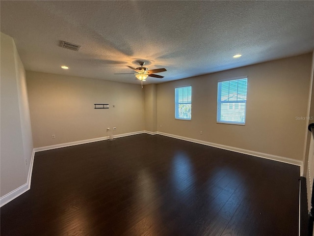 unfurnished room featuring ceiling fan, dark hardwood / wood-style flooring, and a textured ceiling