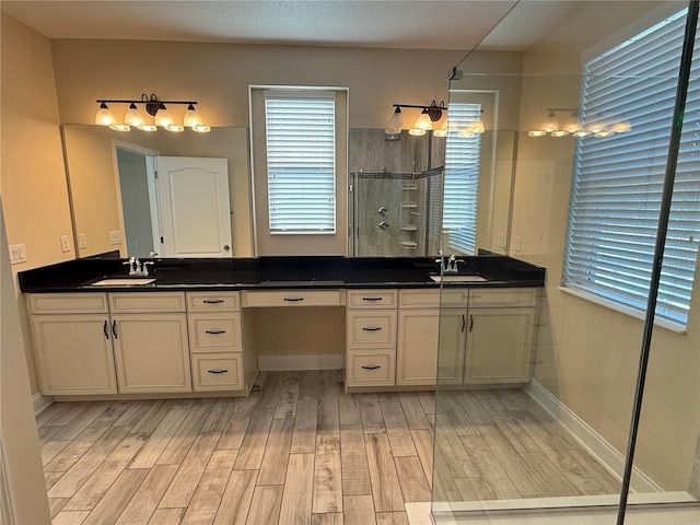 bathroom featuring hardwood / wood-style flooring, a shower with door, and vanity