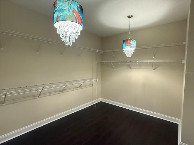 spacious closet with a notable chandelier and hardwood / wood-style floors