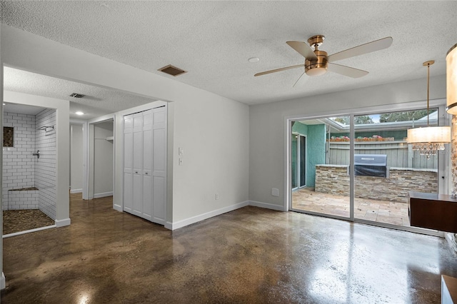 interior space with ceiling fan and a textured ceiling