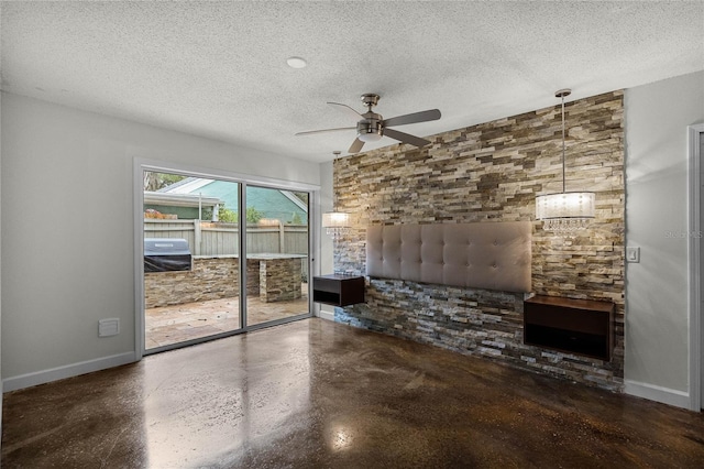 unfurnished living room with ceiling fan and a textured ceiling